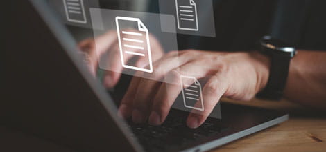 Hands typing on laptop accessing data files